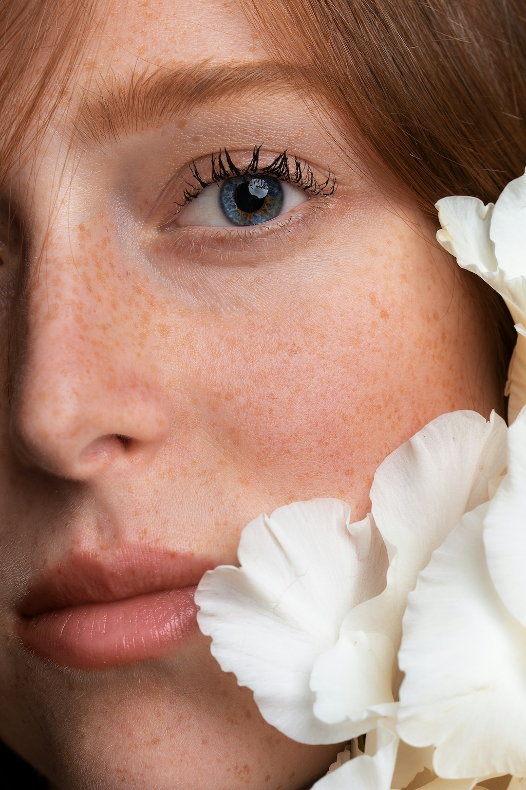 Behandlung mit Polynukleotiden Nahaufnahme eines Gesichts mit natürlicher Haut und weißen Blüten